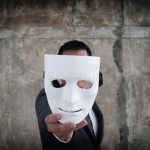 empresario-sosteniendo-máscaras-blancas-en-su-deshonesto-acuerdo-de-engaño-concepto-asociación-empresarial-falso-y-traicionado-157502313